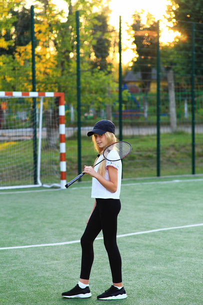 Fille avec une raquette dans ses mains sur le terrain de sport. - Photo, image