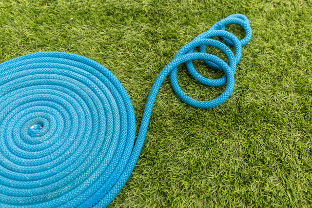 blue rope wound in a circle on the green grass - Foto, Bild