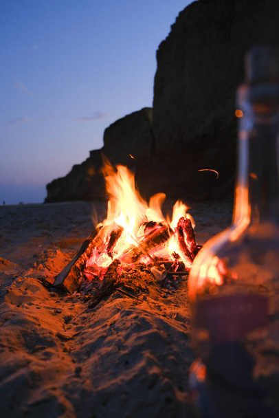 Ognisko na pustej plaży z sylwetką dziewczyny - Zdjęcie, obraz