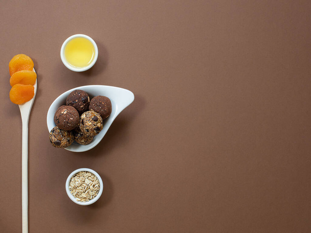 Healthy energy balls with oatmeal, agave syrup, cocoa, and chia seeds on a brown background. Copy space. Top view. - Foto, immagini