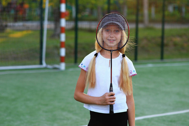 Girl with a racket in her hands on the sports field. - Photo, Image