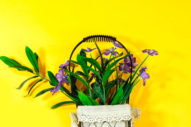 gyönyörű mesterséges lila virágok váza elszigetelt sárga háttér - Fotó, kép