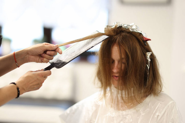 Maître coiffeur teint mèches de cheveux pour le client dans le salon de beauté - Photo, image