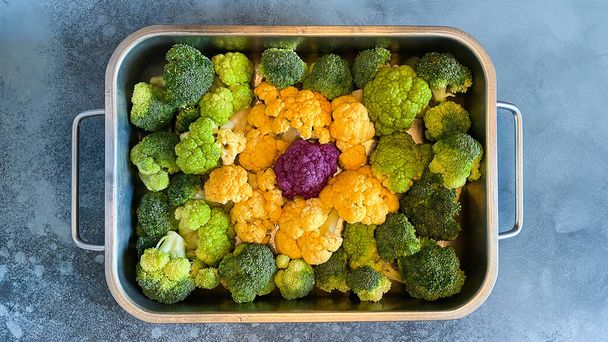 Different colourful cauliflower florets in baking dish before cooking Cabbage gratin. Concept healthy eating. - Fotó, kép