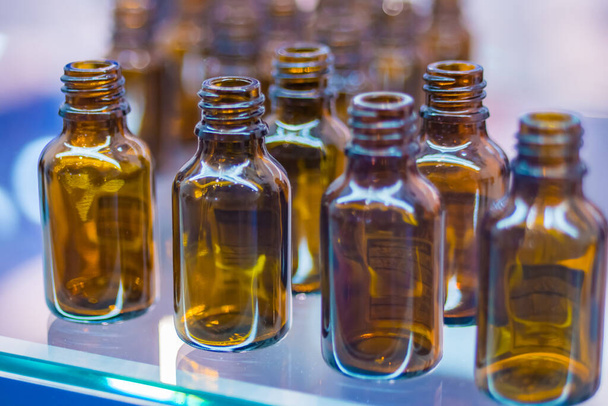 Medical empty glass brown bottles in showcase at pharmaceutical exhibition - Photo, Image