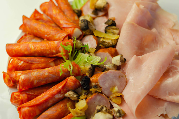 A cold plate prepared for the party with sliced chorizo, ham and sausages, a set of cold cuts - Photo, Image
