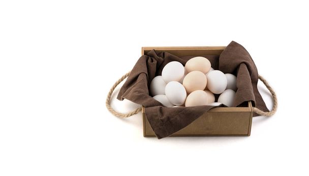 鶏の卵は、茶色のリネンナプキンと美しい木製のパッケージで白と茶色です。. - 写真・画像