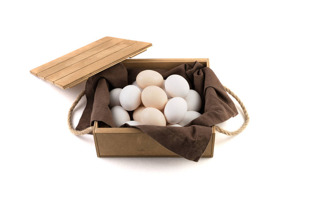 Fresh white and brown chicken eggs are placed in a wooden package with a lid. - Photo, Image