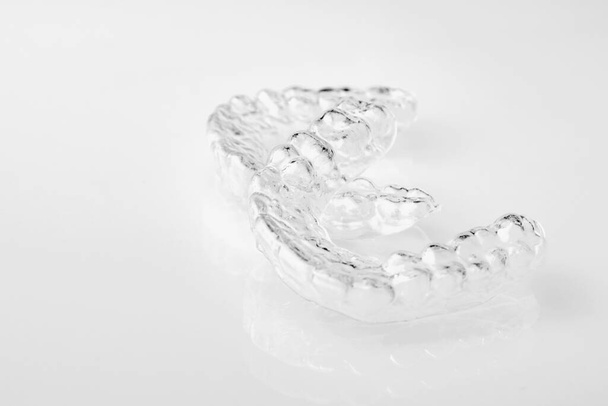 Two Invisible dental teeth aligners on the white background. Orthodontic temporary removable braces for fixing teeth after alignment. Therapy after brackets.  - Фото, зображення