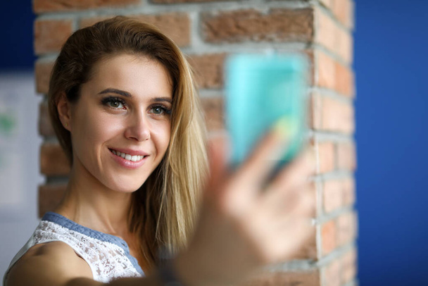 Onnellinen tyttö ottaa selfie älypuhelimeen sisätiloissa - Valokuva, kuva