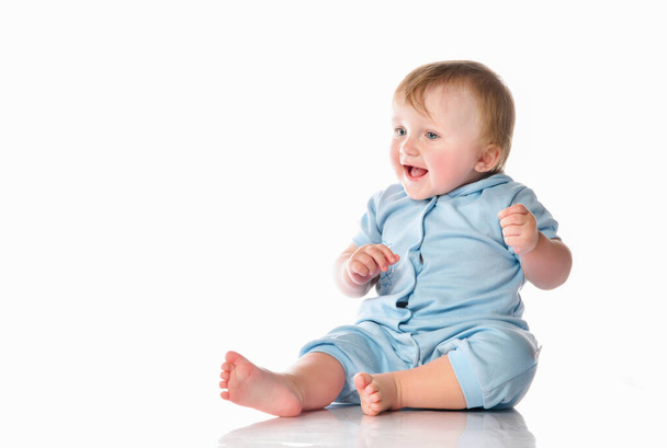 Little boy in a pajama bodysuit is playing in the studio on a white background. - Photo, image