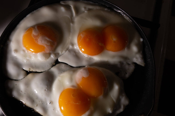 Míchaná vejce ze tří vajec, dvě se dvěma žloutky v pánvi - Fotografie, Obrázek