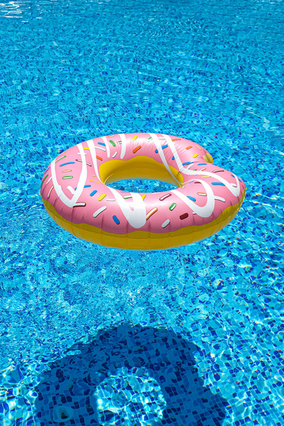 colchón flotante rosado del donut inflable en piscina. Accesorios de piscina de playa. Concepto vacaciones de verano. - Foto, imagen