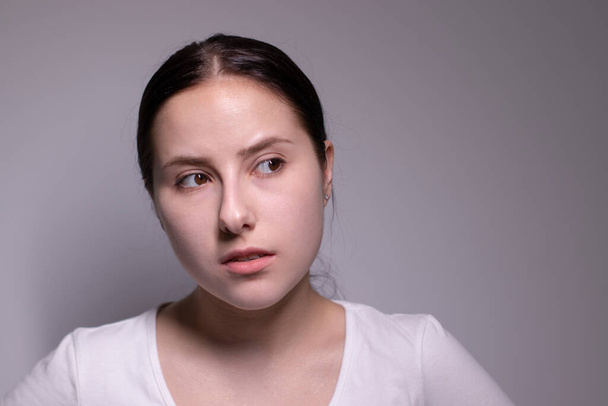  portrait of sad and depressed young woman. on gray background. nervous and upset people concept - Photo, Image