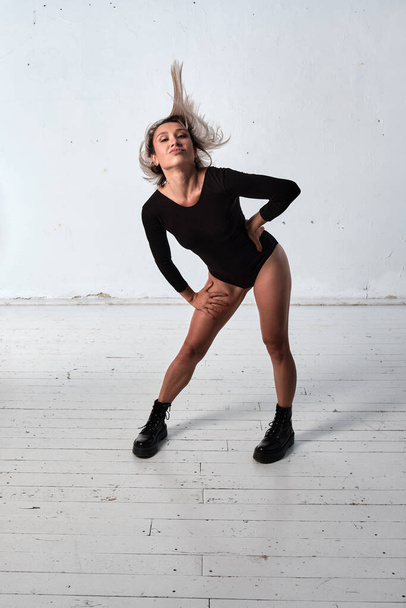 Young adult white woman dressed in body dancing in the studio on wall background. Concept of dancing people. - Photo, image