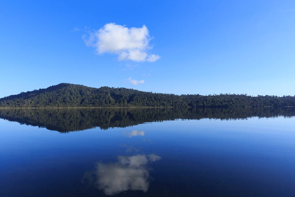 Спокойное зеркальное озеро утром на фоне гор в Новой Зеландии. - Фото, изображение