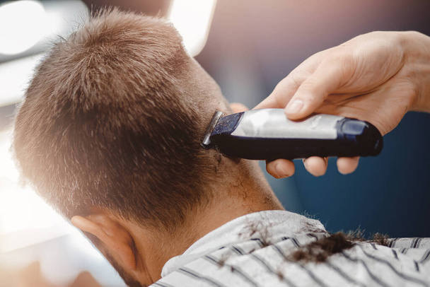 Hairdresser cuts hair men in barbershop. Barber doing correct trim electric shaver - 写真・画像
