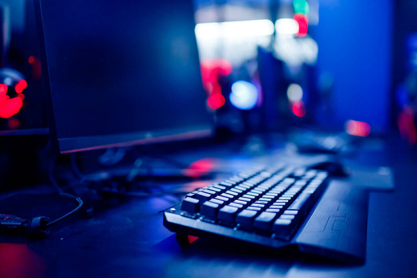 Profesjonalny pokój studio gier wideo z osobistym fotelem komputera, klawiatura do strumienia w neonowym kolorze rozmycia tła. Miękkie skupienie - Zdjęcie, obraz