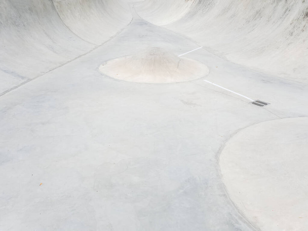 Skatepark de concreto vazio com um obstáculo cone no meio. Foto em tela cheia - Foto, Imagem