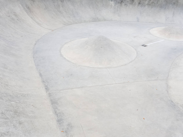 Бетонний скейт-парк з пандусами та конусними бар'єрами. Фотографія на весь екран
 - Фото, зображення