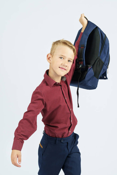 Uczeń trzyma torbę szkolną w górze. Koncepcja edukacji - Zdjęcie, obraz