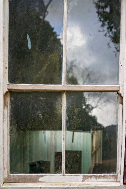 Dilapidated old church hall window covered in cobwebs, with reflections - Photo, Image