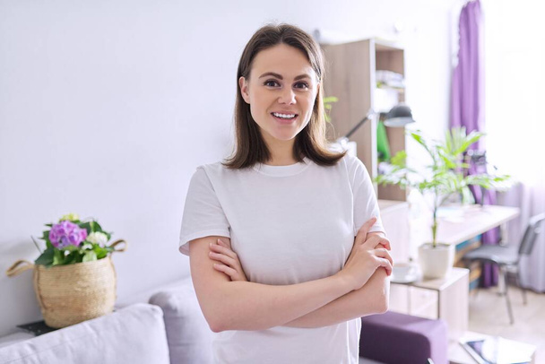 Portrait of happy smiling young woman looking at the camera in home - Photo, Image
