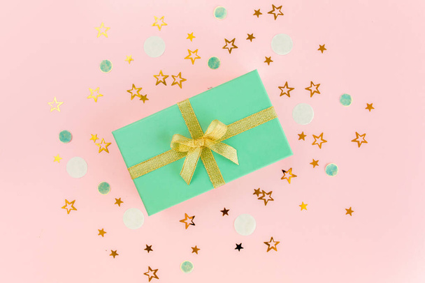Gift or present box and stars confetti on a pink background. Colorful celebration, birthday. Christmas or New Year pattern. Flat lay, top view  - Fotoğraf, Görsel