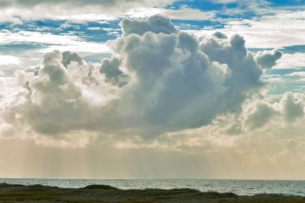 Kuzey denizi üzerinde büyük bir bulut ve güneş ışığı. - Fotoğraf, Görsel