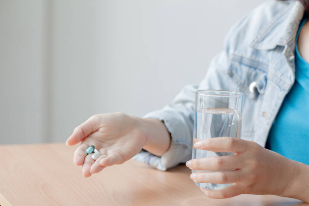Женщины принимают лекарства и держат стакан чистой воды. концепция здравоохранения. - Фото, изображение