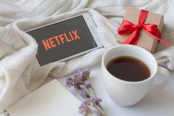 PHITSANULOK, THAÏLANDE - 25 JUIN 2019 : Ouverture de l'application Netflix sur smartphone et du logo Netflix à l'écran. - Photo, image