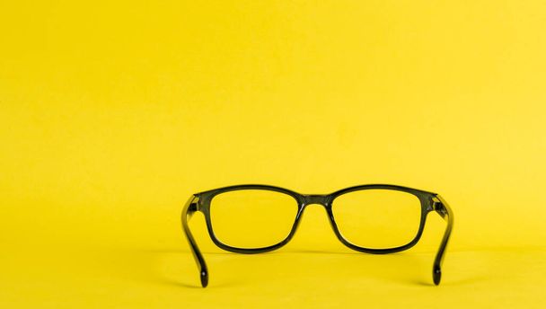 vedere attraverso gli occhiali su uno sfondo giallo e ombra - Foto, immagini