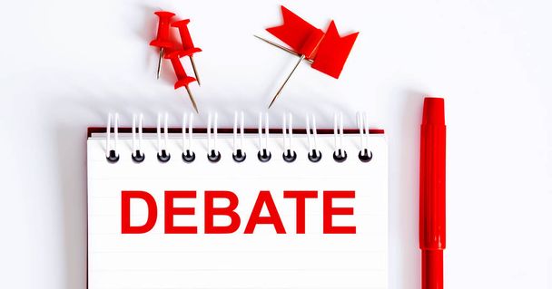 The word DEBATE is written in the notebook with office tools . Business concept - Photo, Image