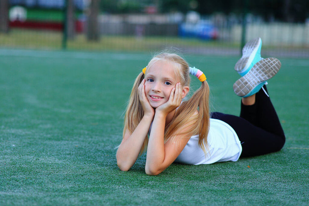 Una ragazza posa vicino a un gol di calcio su un campo sportivo. - Foto, immagini