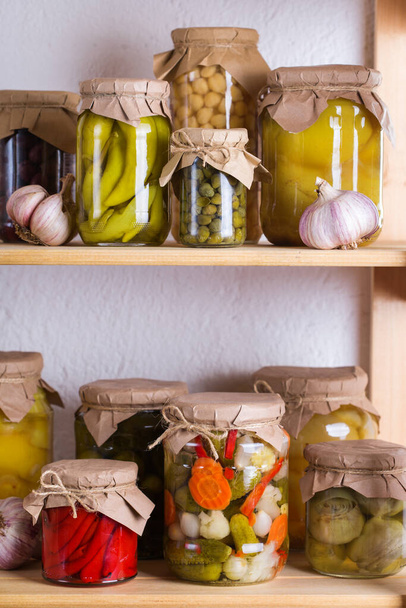 Konservierte und fermentierte Lebensmittel. Auswahl hausgemachter Gläser mit verschiedenen eingelegten und marinierten Gemüsesorten in einem Regal im Abstellraum. Hauswirtschaft, Hauswirtschaft, Ernteerhaltung - Foto, Bild