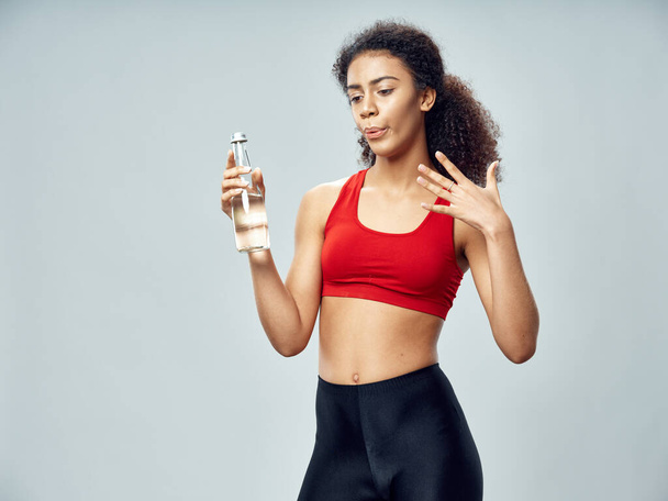Sporty woman holds in hand a bottle with water health exercise  - Φωτογραφία, εικόνα