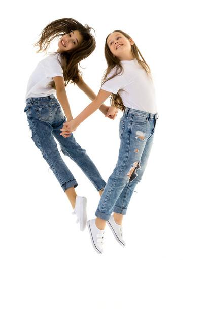 Due bambini felici che saltano subito su uno sfondo bianco - Foto, immagini