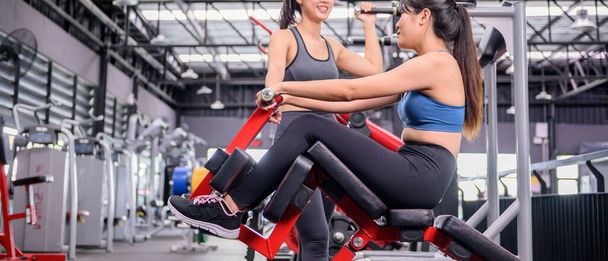 Aziatische vrouw oefening en levensstijl bij fitness gym. Sportieve vrouw workout met trainer. Wellness en gezond voor bodybuilding. - Foto, afbeelding