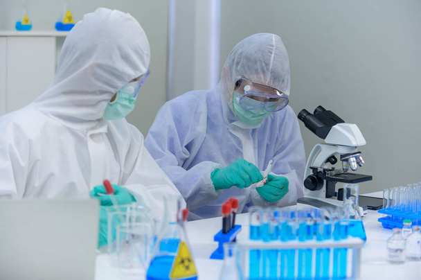 研究室でコロナウイルス治療を研究している科学者チーム。アジアの医師がウイルス感染に対するワクチンの研究を. - 写真・画像