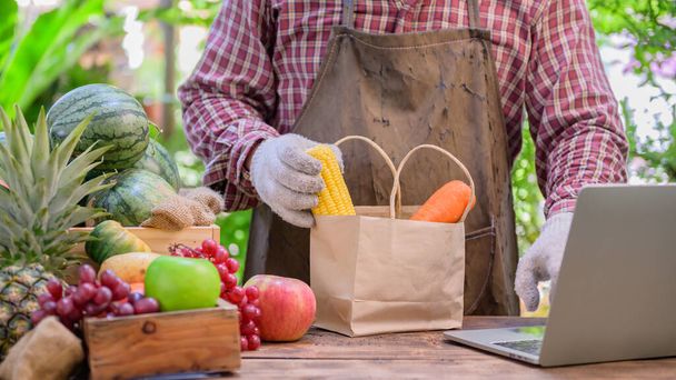 農家は新鮮な果物をオンラインで販売しています。オンラインショッピングと家庭配達の概念。COVID-19後の新しい普通の生活とビジネス。ロックダウンし、自己隔離. - 写真・画像
