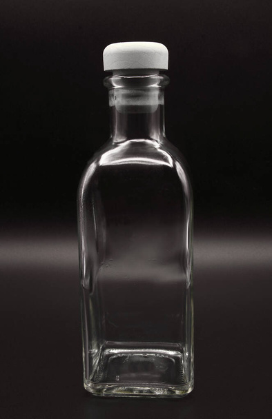 glass bottle, for oil, water or liquids, glass container, transparent, rectangular narrow base, rectangular body, standard neck, circular wide mouth, without lip, without handle, with cork stopper wit - Foto, afbeelding
