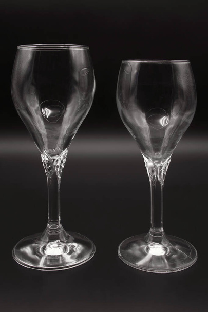Dwa kieliszki kryształowe, do wina, wody, jeden większy, standardowy kielich, długa gruba łodyga, ze standardową okrągłą podstawą, szklany pojemnik, - Zdjęcie, obraz