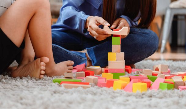 Asian mother work home together with son. Mom and kid play color wooden block. Child creating building toy. Woman lifestyle and family activity. - Fotoğraf, Görsel