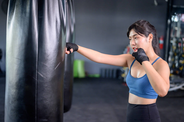 Asiatische Frauen bewegen sich und leben im Fitnessstudio. Sportliches Frauentraining und Boxen mit Trainer. Wellness und gesund fürs Bodybuilding. - Foto, Bild