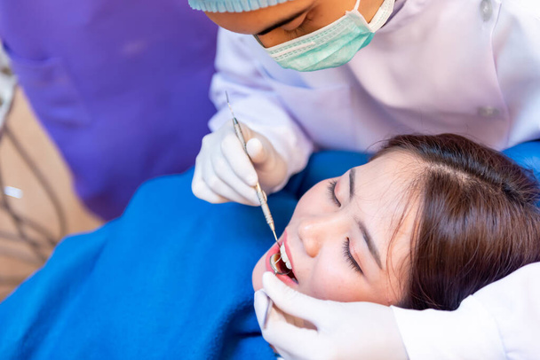 Tandheelkunde en tandenzorg. Tandarts check-up tanden voor Aziatische patiënt. Arts werkzaam in tandheelkundige kliniek en levensstijl. - Foto, afbeelding