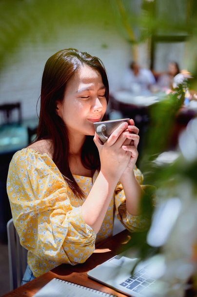 Aasialainen liikenainen verkossa työskentelee kahvilassa. Thai nainen elämäntapa kahvia viikonloppuna. Sosiaalinen etäisyys ja uusi normaali. - Valokuva, kuva