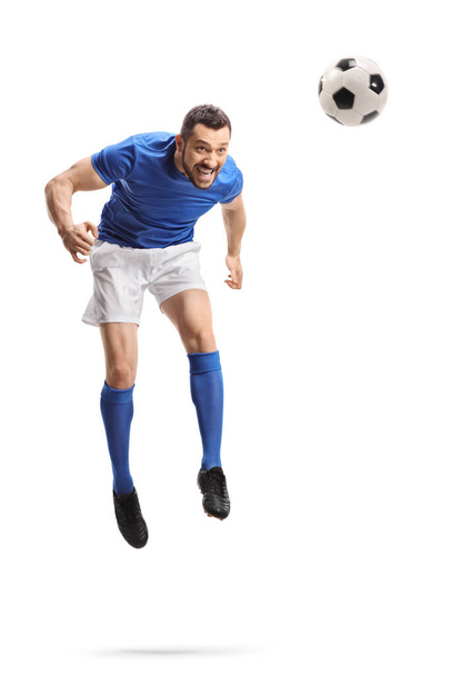 Full length portrait of a footballer jumping and hitting a ball with head isolated on white background - Photo, Image