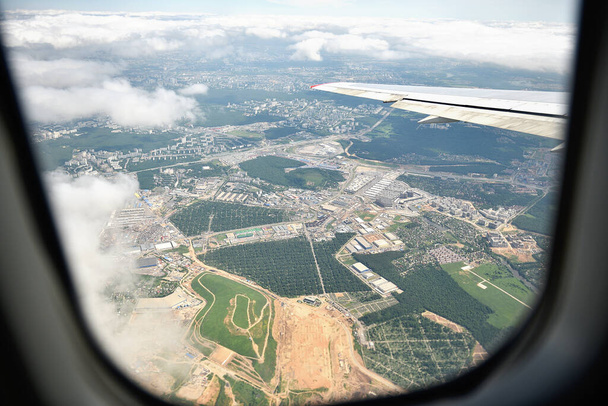 Abstrato vista de ar de alto ângulo da paisagem industrial de avião. Janelas com nuvens brancas claras com janela e asa de avião. Fotografia aérea. - Foto, Imagem