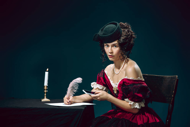 Young woman as Anna Karenina on dark blue background. Retro style, comparison of eras concept. - 写真・画像
