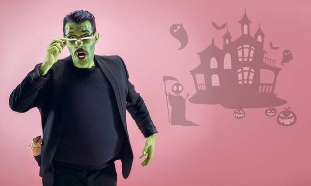 Young man as a zombie on pink background, halloween time, flyer with copyspace - Foto, Bild